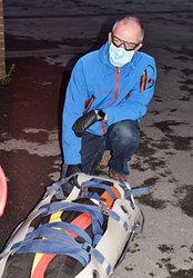 Graham Smith wearing non-sterile gloves, face mask and foam lined safety goggles, with the packaged ‘casualty’.