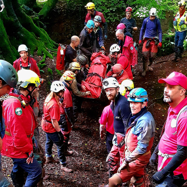 Rescuerers from a range of teams, moving the stretcher